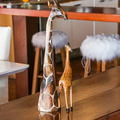 Duas girafas entalhadas em madeira sobre o balcão da sala